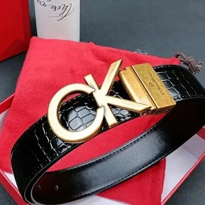 black leather belt with a sculpted gold-tone buckle resting on red cloth