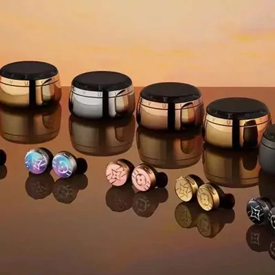 metal earbud cases and open earbuds lined up on an amber-lit surface