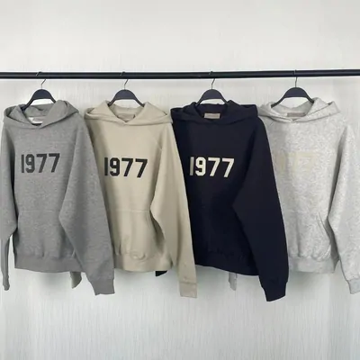three boxy hoodies with a 1977 chest print hanging on a rail