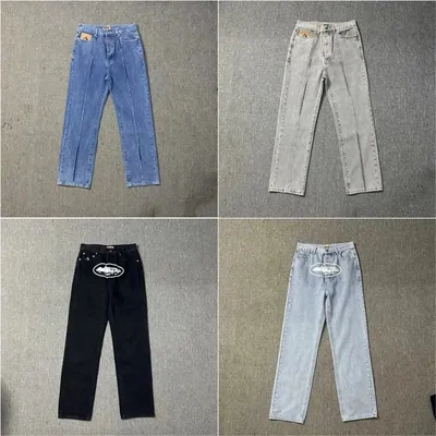 two washed blue pairs of jeans and one black pair laid flat on grey board
